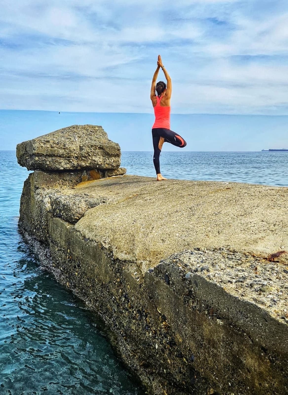 Eva in a yoga pose by the sea